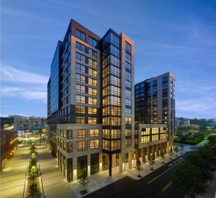 Park + Garden at dusk, a brick and glass mixed-use building in Hoboken